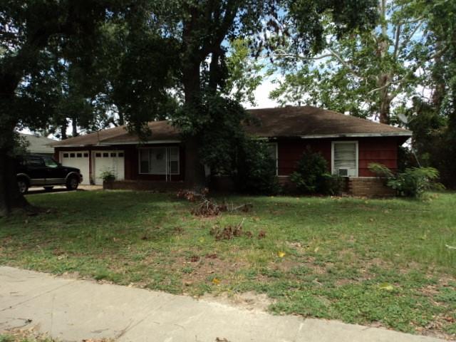 ranch-style home featuring a garage and a front lawn