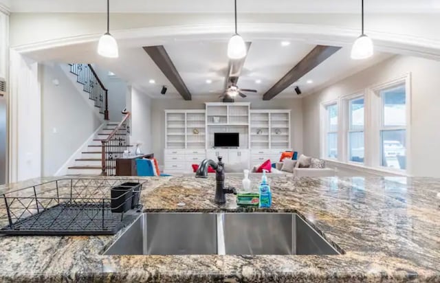 kitchen featuring beamed ceiling, decorative light fixtures, sink, and ceiling fan