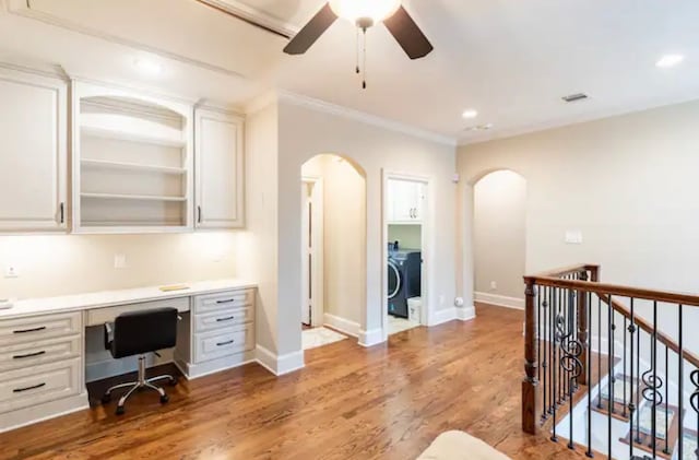 office with built in desk, ceiling fan, washer / clothes dryer, and hardwood / wood-style floors