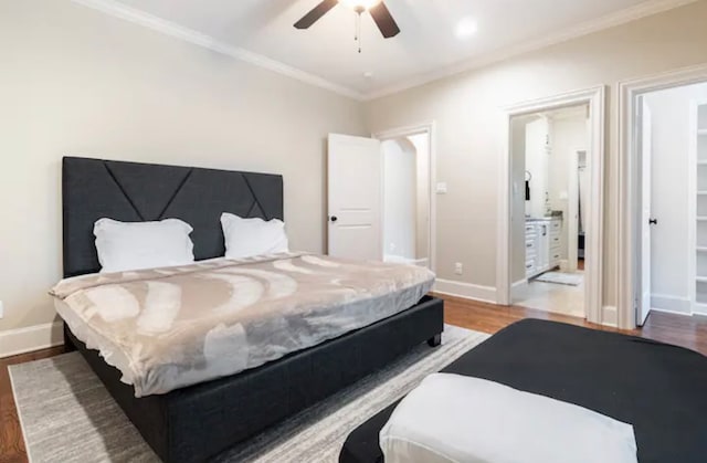 bedroom with ornamental molding, ceiling fan, ensuite bath, and hardwood / wood-style floors