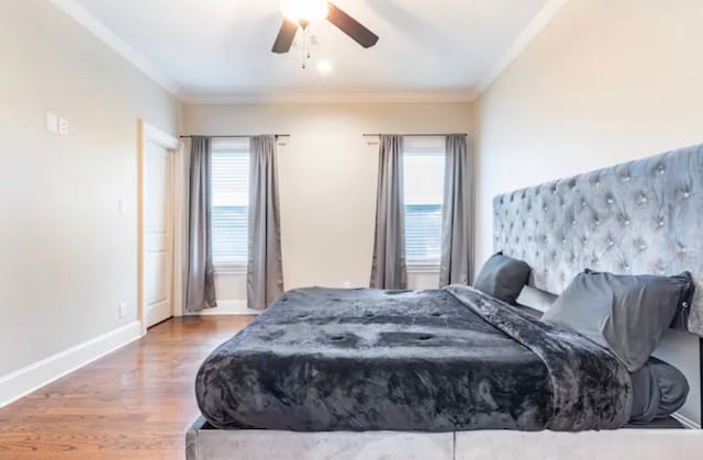 bedroom featuring crown molding, hardwood / wood-style flooring, multiple windows, and ceiling fan