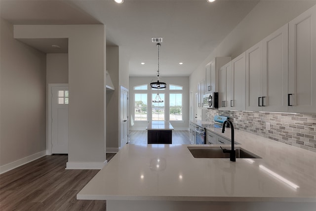 kitchen with decorative backsplash, appliances with stainless steel finishes, sink, pendant lighting, and white cabinetry