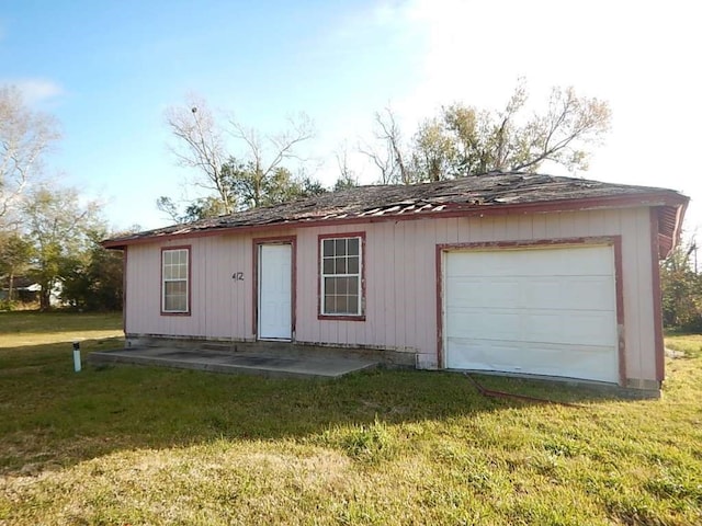 exterior space with a garage and a lawn