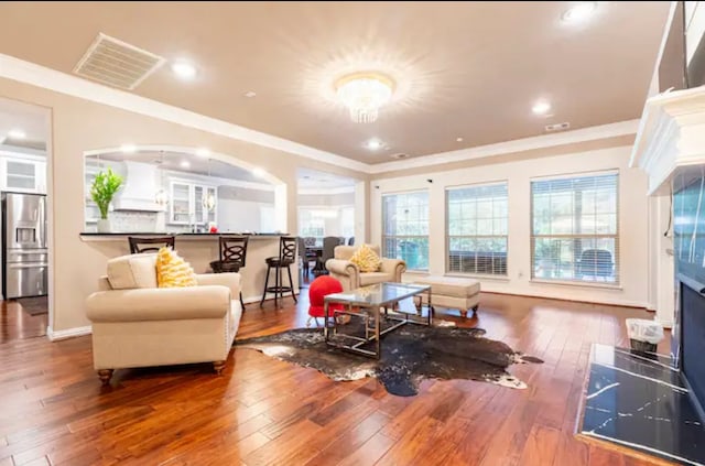 living room featuring a wealth of natural light, ornamental molding, and hardwood / wood-style floors