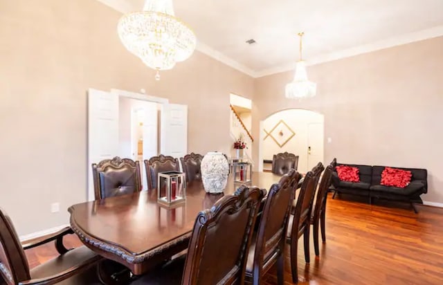 dining space with a notable chandelier, crown molding, and hardwood / wood-style floors