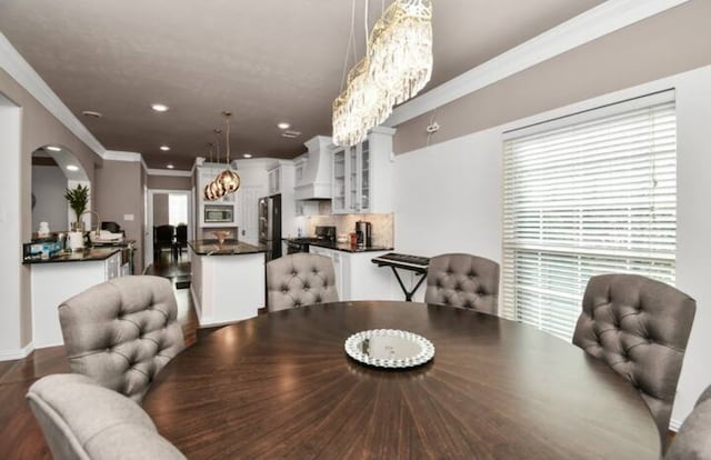 dining space with hardwood / wood-style flooring and crown molding