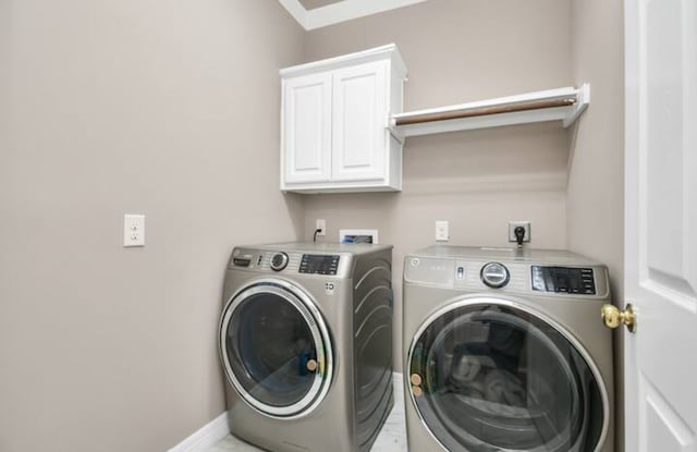 washroom with hookup for a washing machine, washer and clothes dryer, hookup for an electric dryer, and cabinets