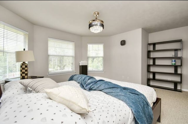 carpeted bedroom with a chandelier