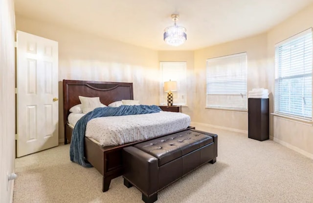 bedroom with an inviting chandelier and carpet