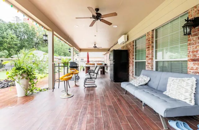 view of patio / terrace featuring a wall unit AC and ceiling fan