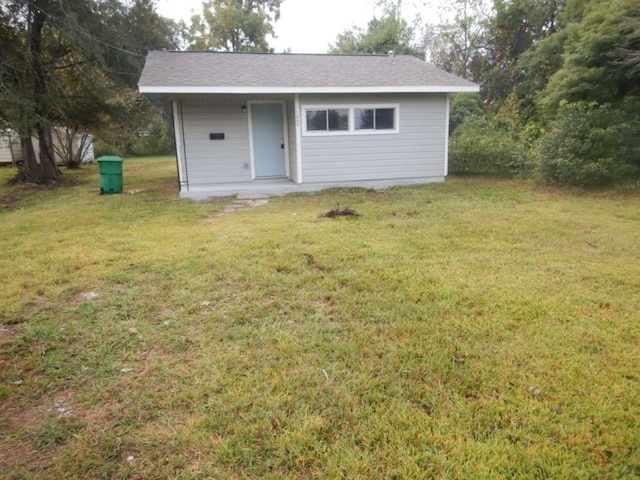 rear view of property featuring a yard