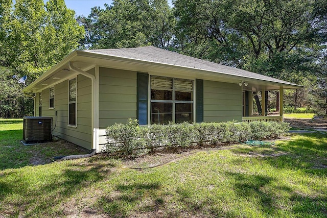 view of side of property featuring a yard and central AC unit