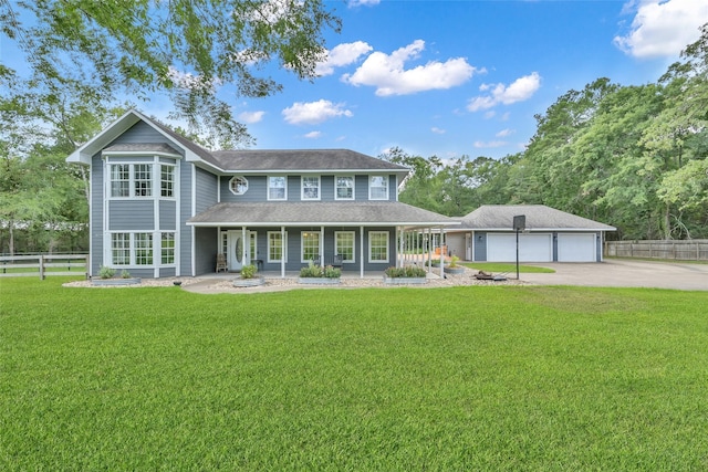 view of front of home featuring a front lawn, covered porch, and a garage