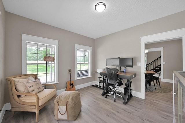 office space featuring a textured ceiling and light wood-type flooring