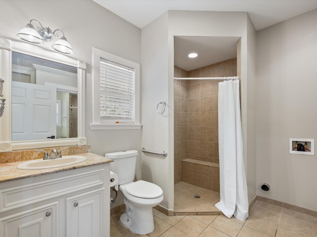 bathroom with tile patterned flooring, vanity, toilet, and walk in shower