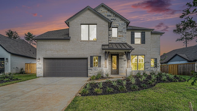 view of front of home with a garage and a lawn