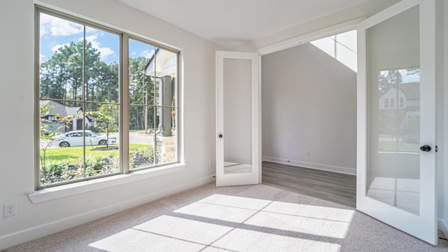 carpeted empty room featuring french doors