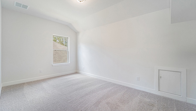 unfurnished room with light carpet and vaulted ceiling