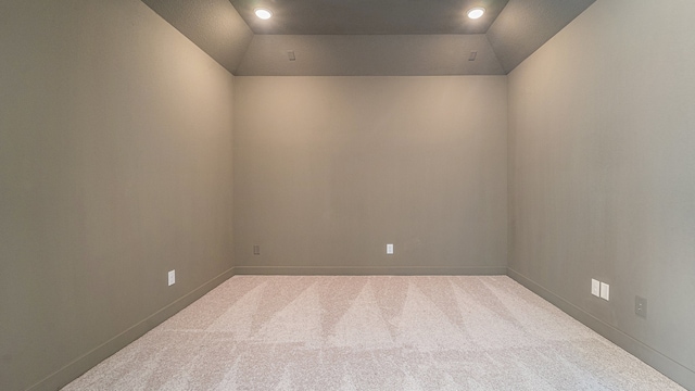 unfurnished room with lofted ceiling and light colored carpet