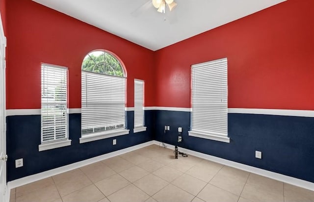 spare room with ceiling fan and light tile patterned floors