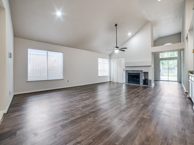 unfurnished living room with ceiling fan, a wealth of natural light, and dark wood-type flooring