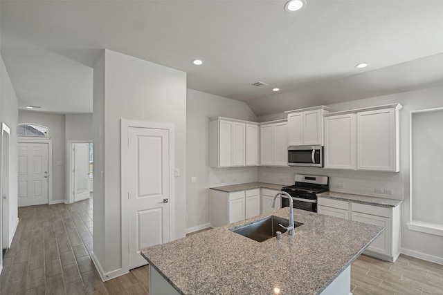 kitchen featuring stainless steel appliances, a kitchen island with sink, white cabinets, and sink