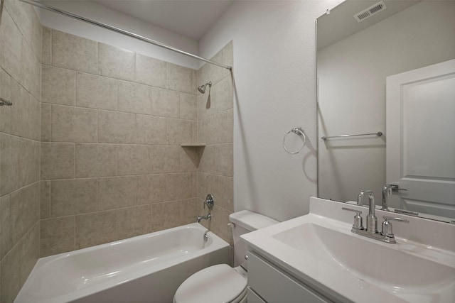 full bathroom with toilet, tiled shower / bath, and vanity