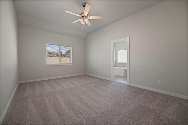 carpeted spare room featuring vaulted ceiling and ceiling fan