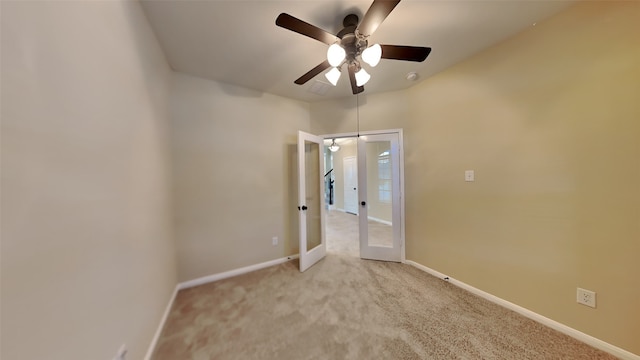 spare room featuring light carpet, french doors, and ceiling fan