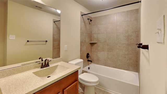 full bathroom featuring a textured ceiling, vanity, toilet, and tiled shower / bath