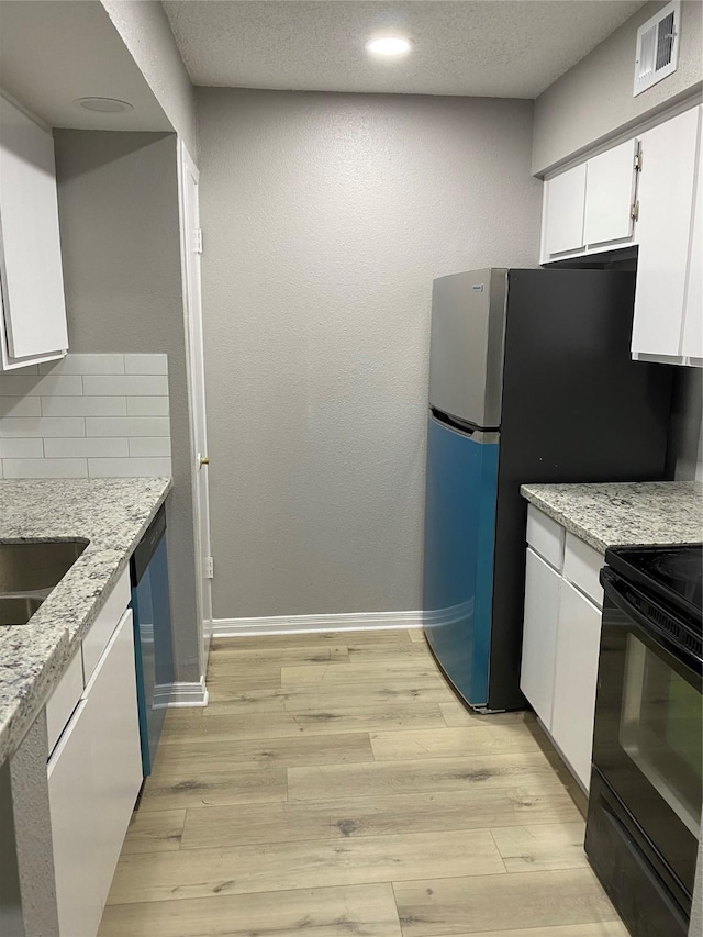 kitchen featuring stainless steel appliances, tasteful backsplash, light stone counters, white cabinets, and light wood-type flooring