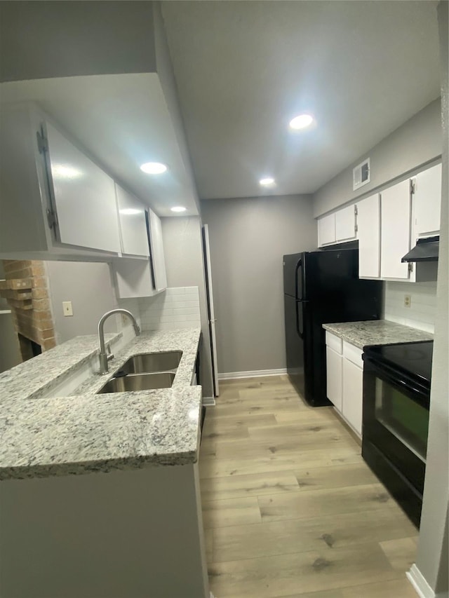 kitchen featuring light stone countertops, sink, white cabinetry, and black appliances