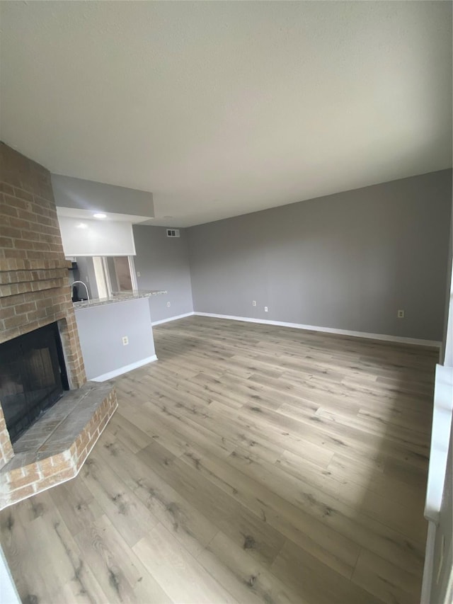 unfurnished living room featuring light hardwood / wood-style floors and a fireplace