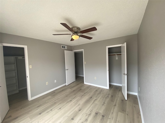 unfurnished bedroom featuring ceiling fan, light wood-type flooring, and a textured ceiling