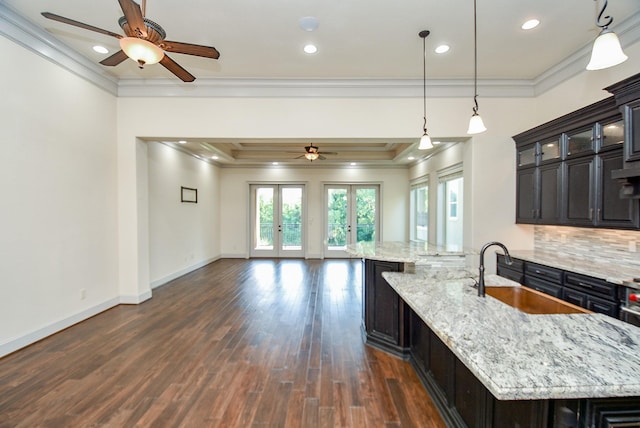 kitchen featuring a large island, french doors, sink, crown molding, and decorative backsplash