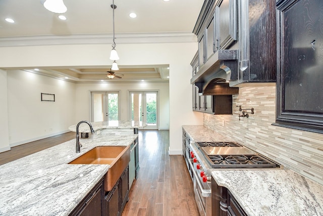 kitchen with french doors, decorative backsplash, light stone countertops, high end stove, and dark hardwood / wood-style flooring