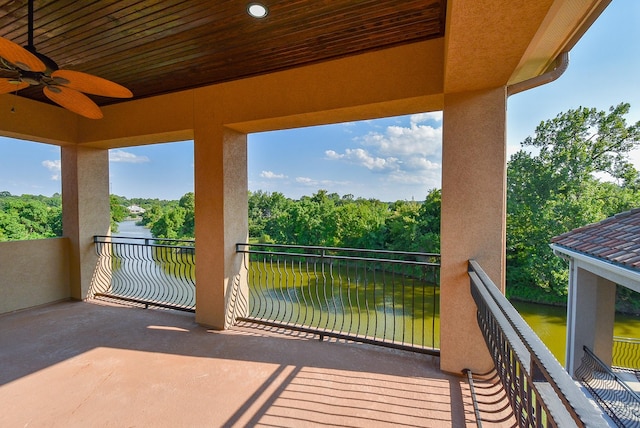 view of patio / terrace with ceiling fan, a balcony, and a water view