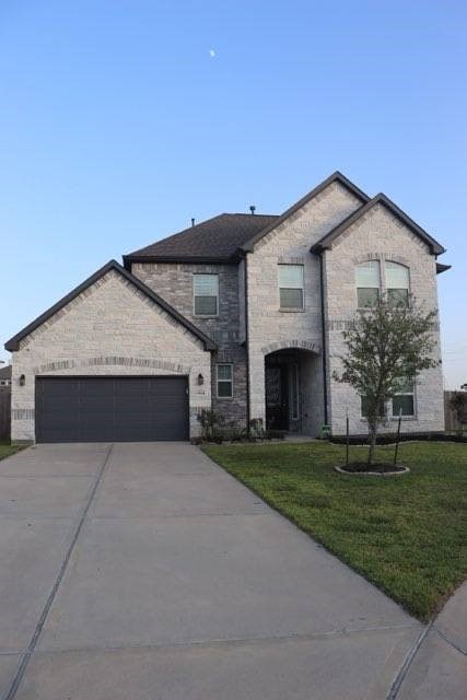 view of front of home with a garage and a front lawn