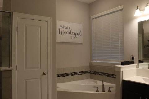 bathroom with plus walk in shower and vanity