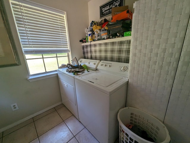 clothes washing area with light tile patterned flooring and separate washer and dryer