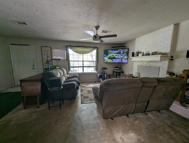 living room featuring brick wall, a brick fireplace, ceiling fan, a textured ceiling, and concrete flooring