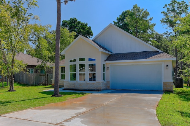 view of front of property featuring a front lawn, a garage, and central AC unit