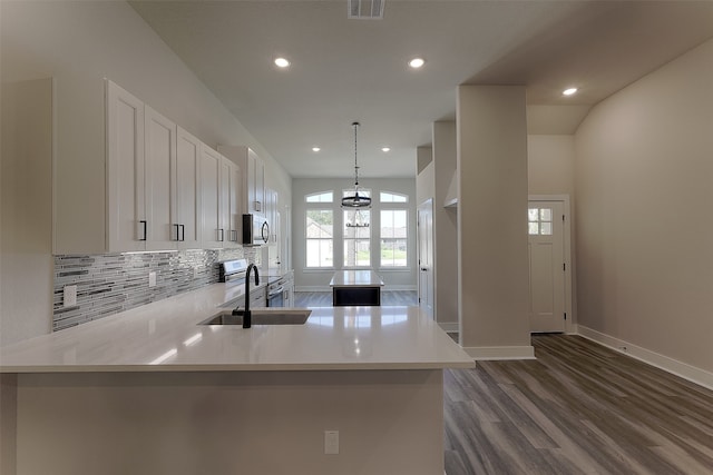 kitchen featuring kitchen peninsula, appliances with stainless steel finishes, pendant lighting, and sink