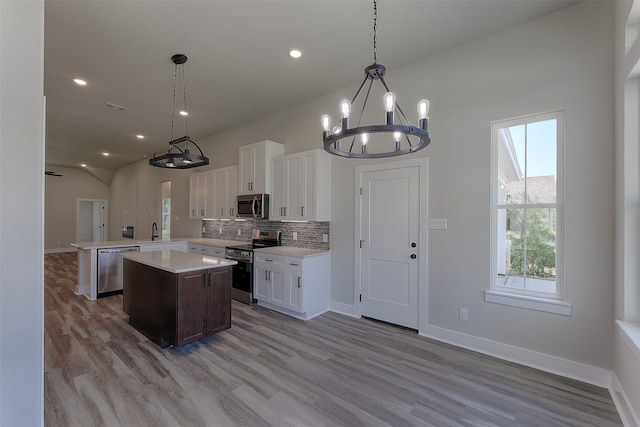 kitchen featuring decorative light fixtures, white cabinetry, and stainless steel appliances