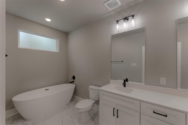 bathroom with a washtub, vanity, and toilet