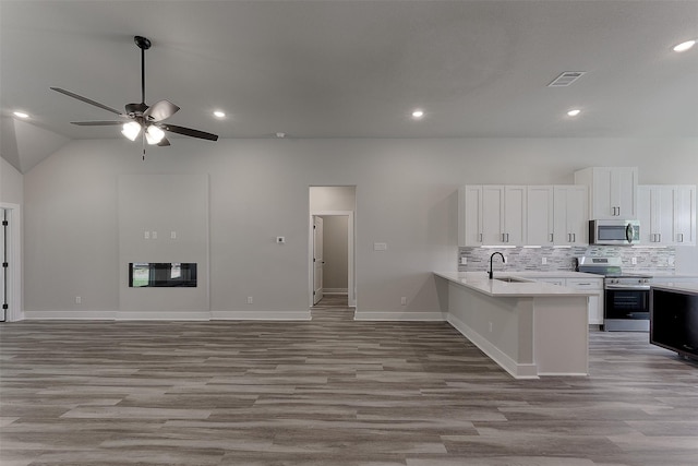 kitchen featuring white cabinetry, sink, kitchen peninsula, light hardwood / wood-style floors, and appliances with stainless steel finishes