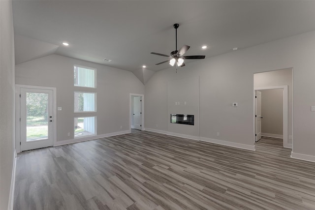 unfurnished living room featuring ceiling fan, vaulted ceiling, and light wood-type flooring