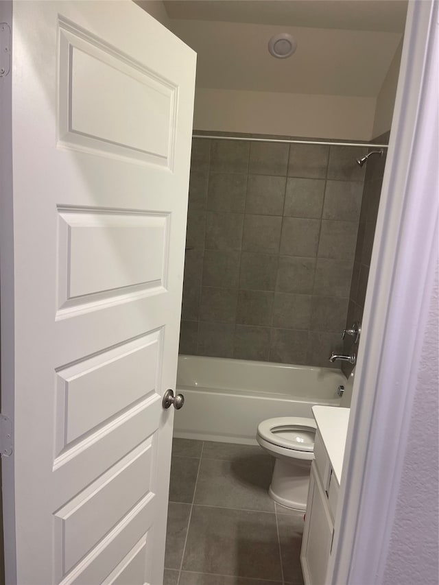 full bathroom with tiled shower / bath, vanity, toilet, and tile flooring