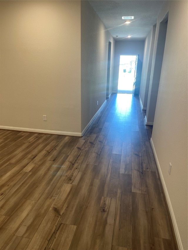 hallway with dark hardwood / wood-style flooring