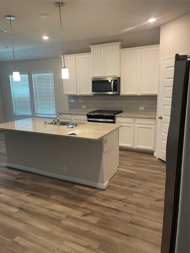 kitchen featuring stainless steel appliances, backsplash, hanging light fixtures, white cabinetry, and dark wood-type flooring